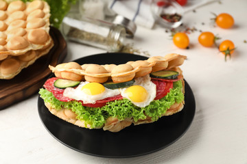 Delicious bubble waffle with fried eggs on plate