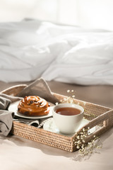 Wicker tray with delicious breakfast on bed