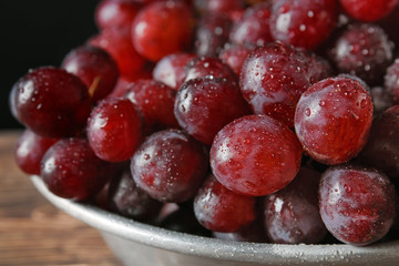 Juicy ripe grapes in bowl, closeup
