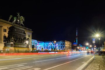 Fototapeta na wymiar Night scenery of street, statue iconic monument, Humbolt university building and background of Berliner Fernsehturm in Berlin, Germany with long exposure and slow shutter speed photography style. 