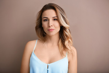 Portrait of beautiful young woman on color background