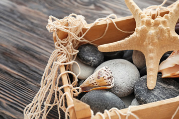 Sea shells and stones in wooden box, closeup