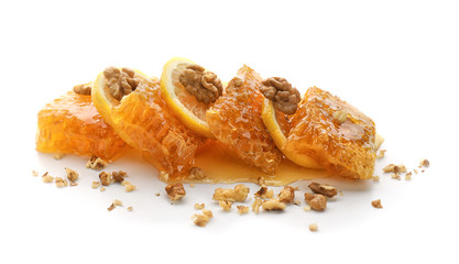 Honeycomb, lemon slices and nuts on white background