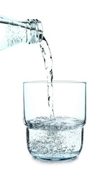 Pouring of water in glass on white background