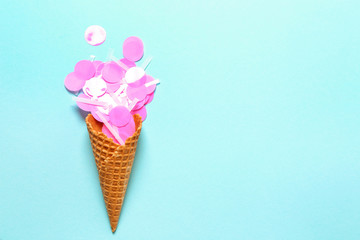 Waffle cone with confetti on color background