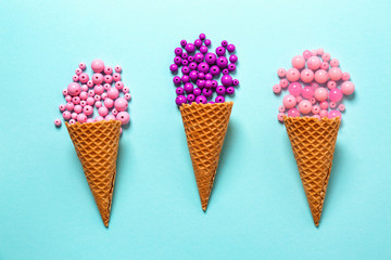Waffle cones with beads on color background