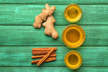 Glass bowls with fresh honey, cinnamon and ginger on color wooden table © Pixel-Shot