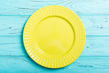 Empty yellow plate on wooden table