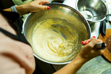 mixing cream with a whisk in a metal plate