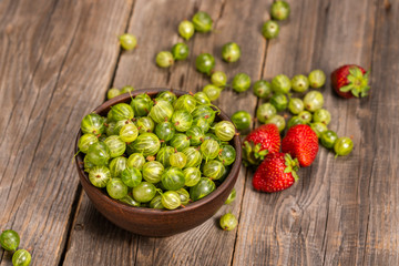 strawberries and gooseberries in the garden on the table