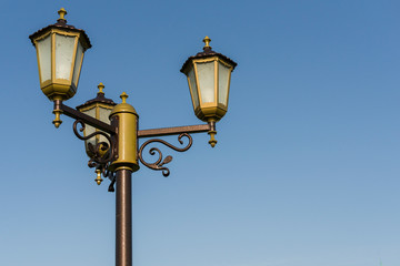 Fototapeta na wymiar stylized antique street lamp against a blue sky