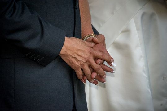 pareja tomada de la mano en una boda con anillos de compromiso