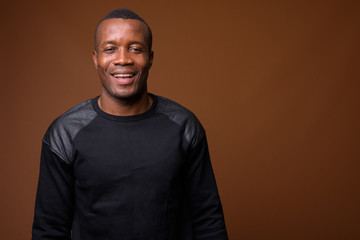 Obraz premium Studio shot of young African man against brown background