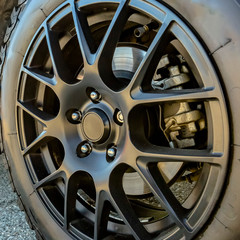 Black tire rim and disc brake of car on sunny day