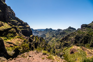 Active lifestyle. Hiking on the beautiful but dangerous hard trekking trail leading from Pico Arieiro peak to the highest mountain of Madeira island, Pico Ruivo