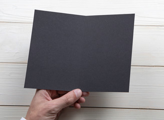 Mens hands holding empty black booklet
