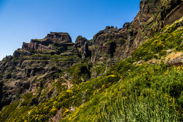 Naklejka premium Active lifestyle. Hiking on the beautiful but dangerous hard trekking trail leading from Pico Arieiro peak to the highest mountain of Madeira island, Pico Ruivo