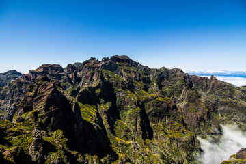 Active lifestyle. Hiking on the beautiful but dangerous hard trekking trail leading from Pico Arieiro peak to the highest mountain of Madeira island, Pico Ruivo