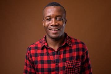 Obraz premium Studio shot of young African man against brown background