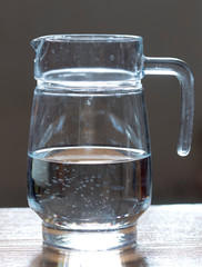 The water in the decanter is on the table