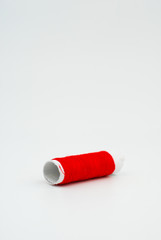Red cotton thread on white background.