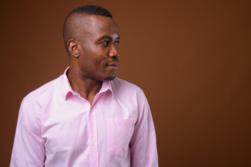 Obraz premium Studio shot of young African businessman against brown backgroun