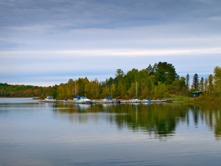 Beautiful Minnesota lake with reflection of marina and boats on cloudy day