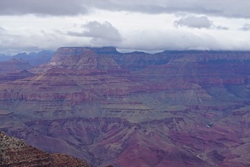 Fototapeta na wymiar Grand Canyon National Park, Arizona: The muted purple, red, and brown colors of the Grand Canyon under a low cloud cover, seen from the Desert View area of the South Rim.