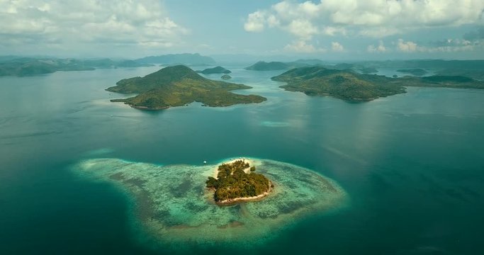 Aerial - flying over paradise tropical island, pristine turquoise water, white sand beach, idyllic lagoon. Coron, Palawan, Philippines