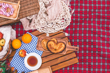 Summer picnic with a basket of food on blanket in the park. Free space for text
