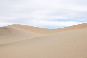 Fototapeta na wymiar Sand dunes clean background with cloudy sky
