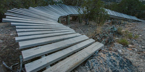 Curving wooden trail on a rocky sloping hill