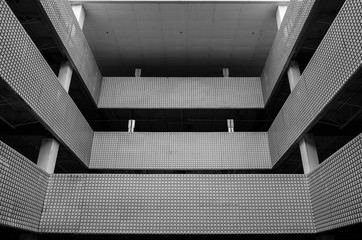 Abstract architectural design. Modern building exterior facade. Corporate building interior design. Industrial garage architecture. Artistic design and detail. Black and white photography. 
