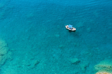 Naklejka premium Boat floating in blue green waters of the Mediterranean Sea in the Cinque Terre area of Italy seen from above