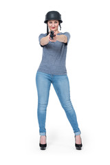 Young girl in casual clothes in a military helmet with a shotgun, isolated on white background