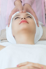 Fototapeta na wymiar Woman lying in bed relaxing in spa.Woman is lying on the spa bed to do a facial scrub.Spa facial massage in beauty salon.