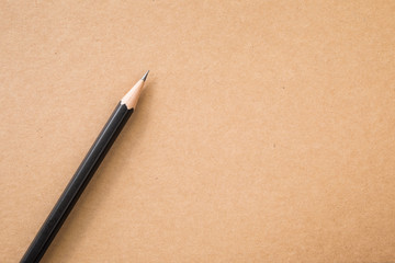 Pencil on brown kraft paper texture top view for background