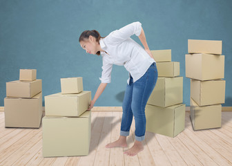 woman suffering from backache while moving boxes