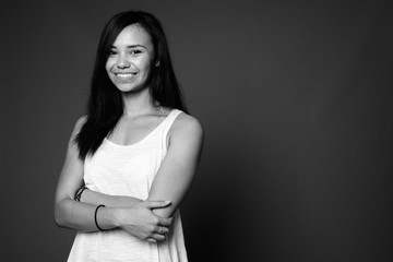 Young Asian woman against gray background in black and white