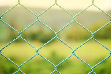 Fototapeta premium Steel fence on green field