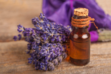 Essential lavender oil with a lavender flower on a rustic background