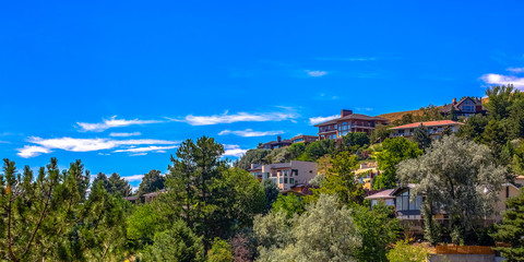 Fototapeta na wymiar Homes on hill under blue sky in Salt Lake City