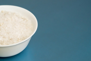 sea salt in a white Cup on a blue light background, place under the text
