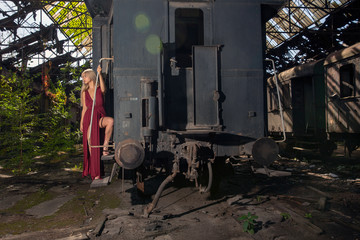 Fototapeta premium Woman in red dress posing at the end of the train