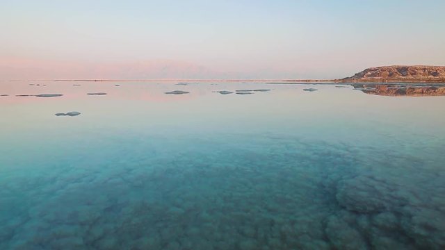 Dead Sea coastline with salt beach and mountains, Israel, Middle East. Pan shot.