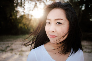 Fototapeta premium Beautiful woman walk outdoor along with sand and pine under warm sunlight.
