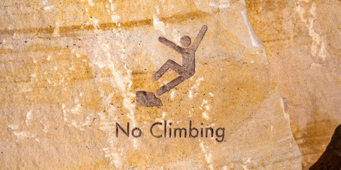 No climbing sign engraved on brown rock