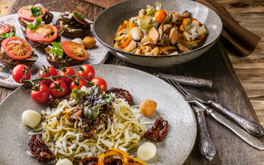 Spaghetti with pesto, salad with mussels and canapes with tomatoes. Mediterranean Kitchen.