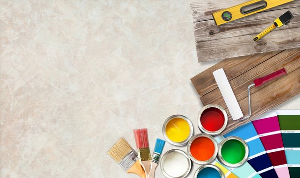 Paint brushes and paint cans for  repair on wooden background