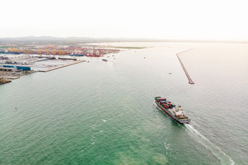 Obraz premium Aerial view of Small container ship at sea freight, Business International trade and Container logistics export-import harbor to the International port / Shipping Containers concept.